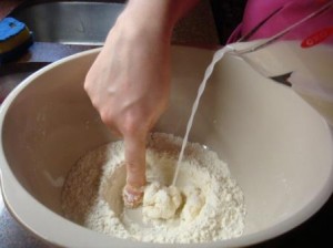 Mixing the water and yeast into the flour to make pizza dough