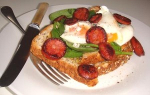 Sauteed chorizo sausage and poached eggs on toast with spinach
