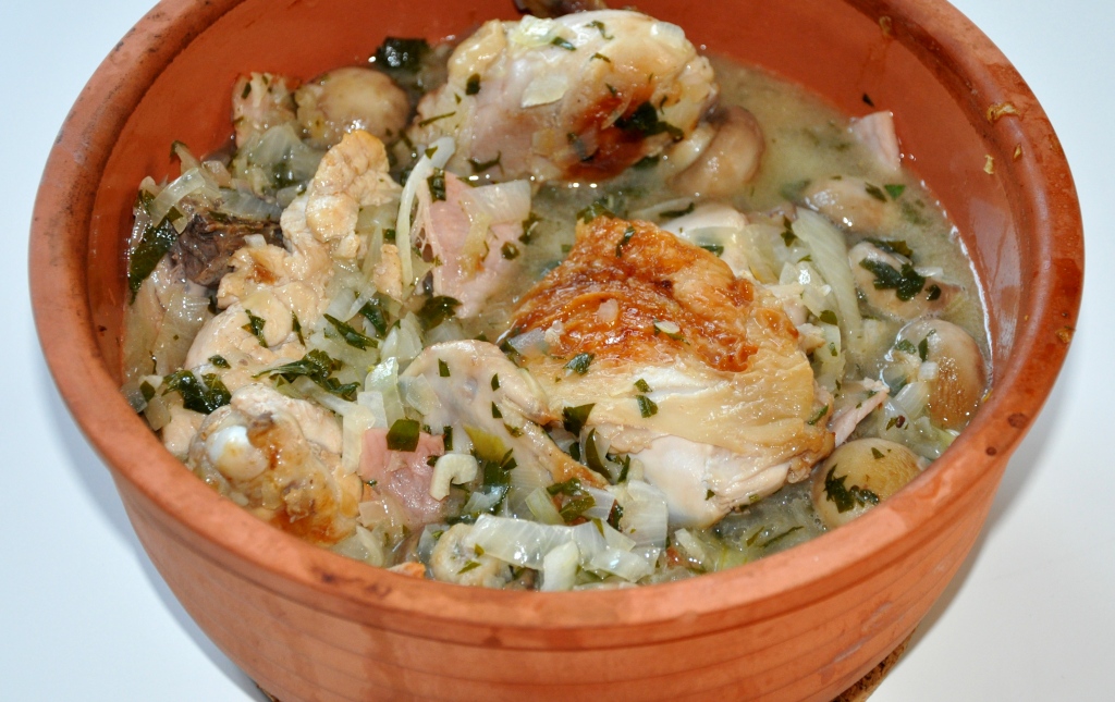 Coq au vin in a earthenware bowl