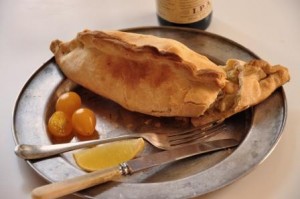 An image of a seafood pasty on a metal plate