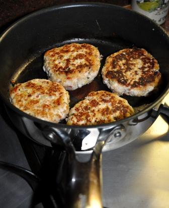 An image of chicken burgers in the pan