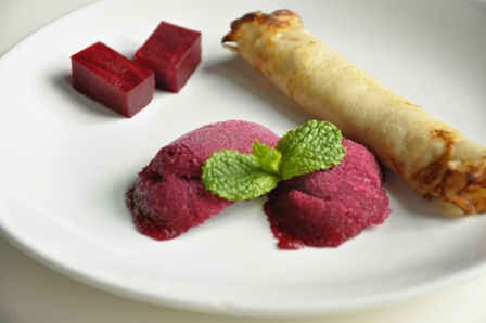 An image of beetroot sorbet with mini pancakes and mint