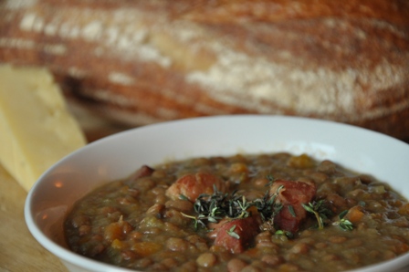 An image of bacon and pea soup in a bowl with bread