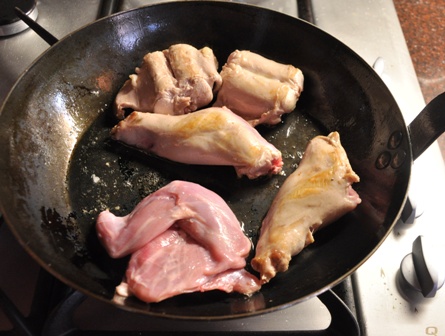 An image of rabbit portions in a frying pan