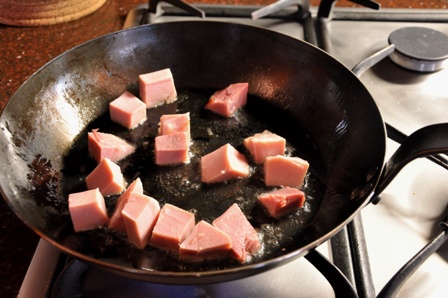 Bacon pieces cooking in a pan
