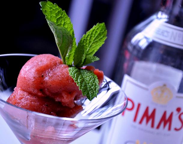 An image of Pimms sorbet in a martini glass with Pimms bottle