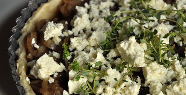 A close up image of onion and feta tart.