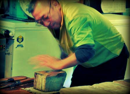 An image of a man sharpening a knife at Tsukiji fish market.