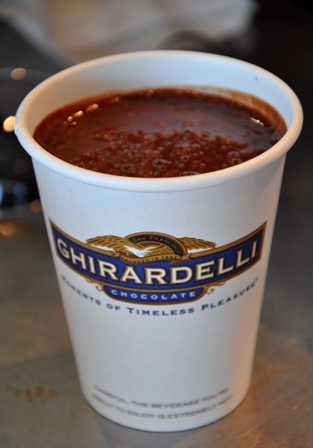 An image of a decadent Ghirardelli hot chocolate in a disposable cup