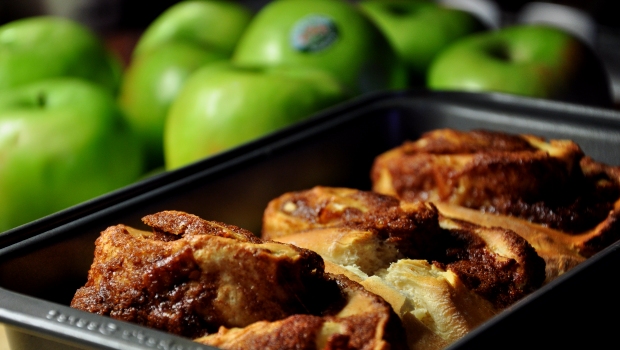 An image of cinnamon and apple rolls with granny smith apples