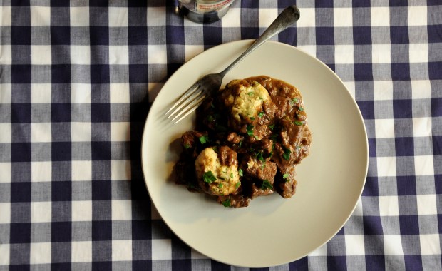 An image of beef stew and dumplings on the table