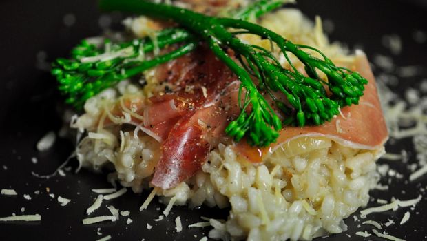 Risotto with prosciutto in a dark plate