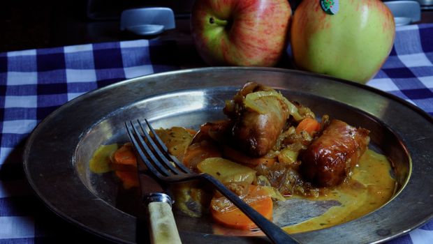 sausage casserole on metal plate with apples