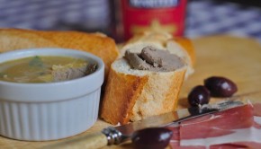 An image of chicken liver pate with bread and olives
