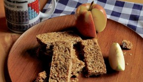 An image of flapjacks and apple on a wooden plate