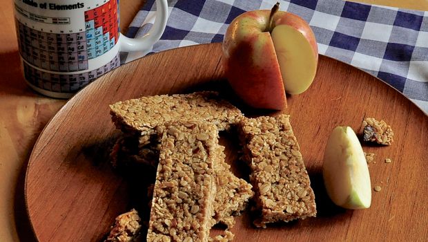 An image of flapjacks and apple on a wooden plate