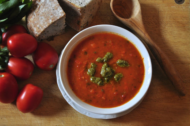 roast pepper soup in a white bowl with tomatoes and bread