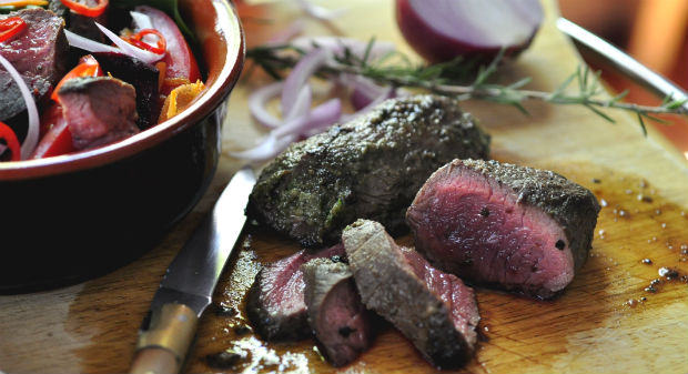 Anti-oxidant salad with freshly cooked kangaroo steak on a board