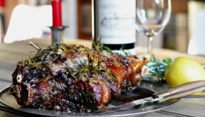 Roasted leg of wild goat with lemon and rosemary rub on a metal plate