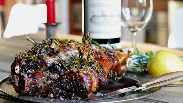 Roasted leg of wild goat with lemon and rosemary rub on a metal plate