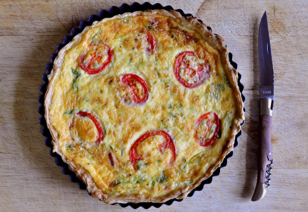 bacon and spring onion quiche on a chopping board